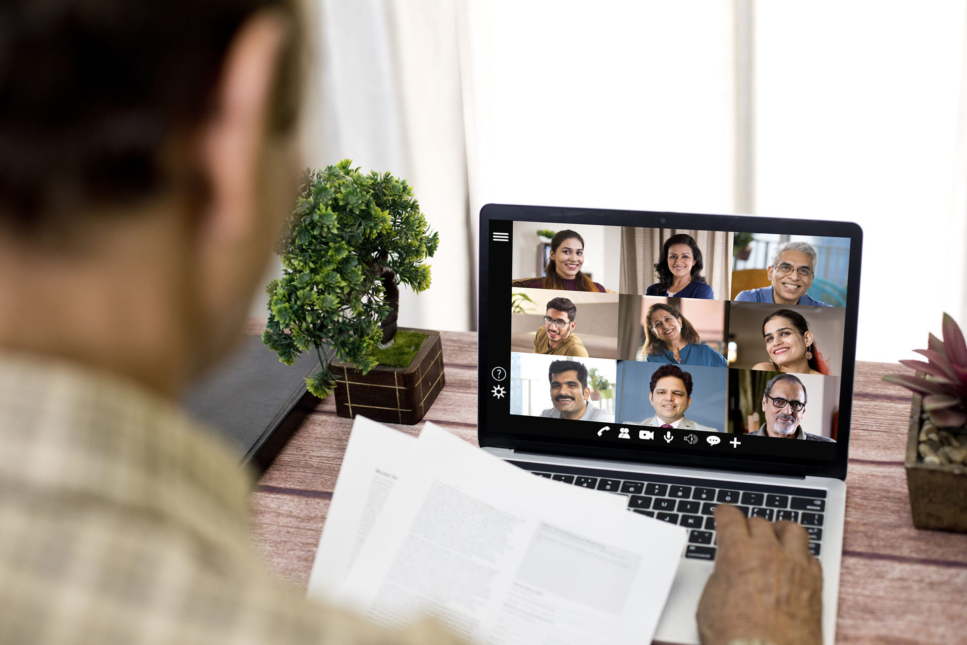A man attends a remote video conference meeting on laptop at home